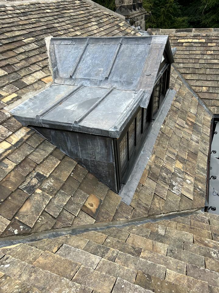Lead-clad dormer on a stone slate roof